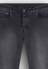 Jeans de mezclilla negra con una textura suave, diseño de cinco bolsillos, cierre de botón y un ligero desgastado. Corte recto y ajuste estándar.