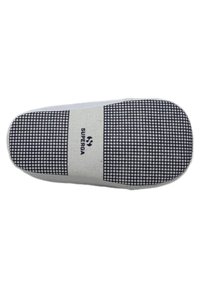 Sole di sneaker bianca con motivo a griglia nera, logo del marchio "SUPERGA" in nero, materiale in gomma, design piatto, superficie liscia.