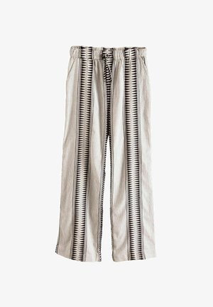 Laiad püksid tekstureeritud kangast, millel on valged ja mustad vertikaalsed triibud ning kolmnurkade mustrid, elastne vöökoht ja paeltega detail.