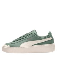 Green leather sneaker with a white midsole, rounded toe, and textured rubber outsole. It features a lace-up design and side logo detail.