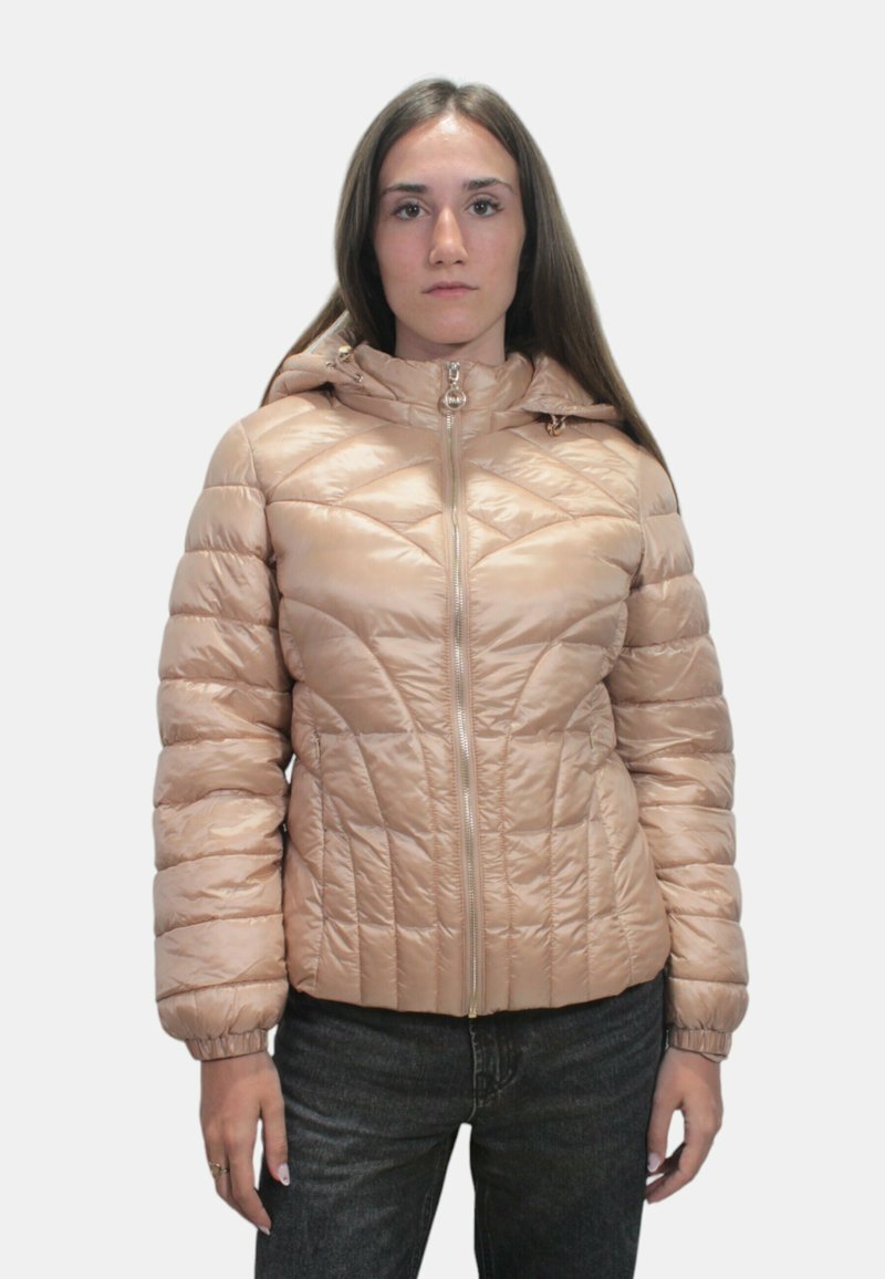 Giacca imbottita in morbido tessuto color sabbia con zip frontale, cappuccio e motivo trapuntato. Presenta polsini arricciati e una silhouette aderente.