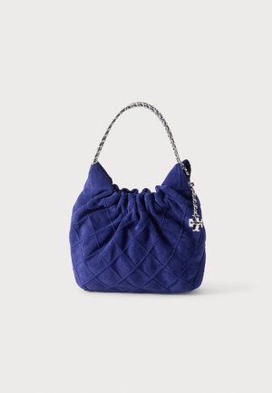 Sac à main matelassé bleu marine avec une anse chaîne argentée et un petit porte-bonheur logo argenté sur le côté droit.