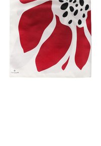 Czerwony szalik w kwiatowy wzór na białym tle, wykonany z gładkiego materiału. Posiada duże płatki i akcenty w czarne kropki. Zawiera logo TATUUM.