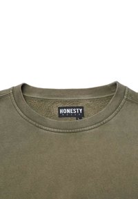 Olivgrön rundhalsad sweatshirt med fleecefoder och en svart lapp med texten "Ärlighet Regler" i vit text, storlek stor.