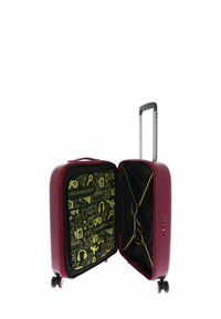 Valise rigide bordeaux ouverte avec une poignée télescopique, quatre roues, des sangles intérieures et un revêtement intérieur jaune illustré d'icônes de voyage et du texte "Mandarina Duck".