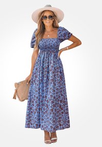 Abito lungo floreale blu con scollatura quadrata, maniche a sbuffo e corpetto arricciato. Presenta una vestibilità ampia ed è abbinato a una borsa color beige.