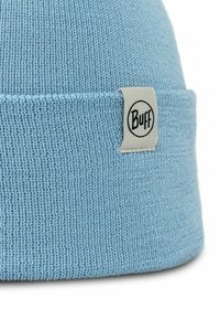 Gorro de punto azul claro con vuelta, que presenta una etiqueta con el logo circular "Buff" bordada en el costado. Textura suave y diseño sin costuras.