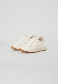Baskets blanches avec accents beiges, dotées d'un dessus en synthétique lisse, de détails texturés, d'un bout rond et d'une semelle en caoutchouc.