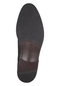 Schwarze Ledersohle mit runder Form, geprägtem Branding, feiner Naht und einer leichten Textur über der Oberfläche.