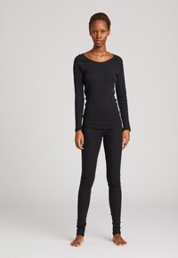 Sort langærmet top og tætsiddende leggings lavet af et tekstureret materiale, med en rund halsudskæring og slim-fit design.