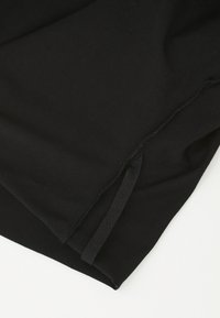 Black fabric with a smooth texture, featuring a visible seam and a fabric tie. The shape is rectangular, with a clean edge.
