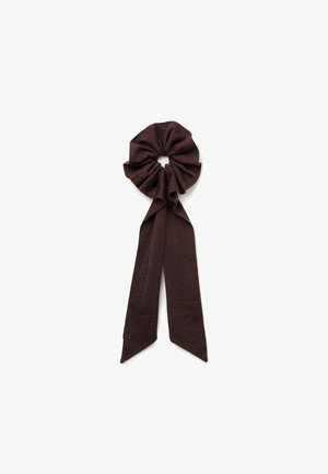 Bordeaux-farbener Stoffscrunchie mit geraffter Textur, der einen zentralen kreisförmigen Abschnitt und zwei elongated, nach unten verjüngte Enden hat.
