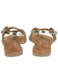 Sandali piatti metallici dorati con design open toe, cinturini sottili e soletta texturizzata. Chiusura con fibbia e decorazioni in perline sui cinturini.