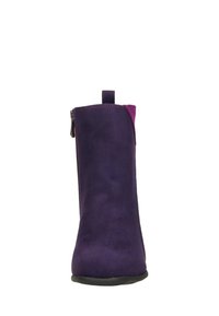 Bottine en suede violet avec une semelle en caoutchouc noir, fermeture éclair latérale et accent magenta contrastant à l'arrière. Texture lisse avec des lignes épurées.