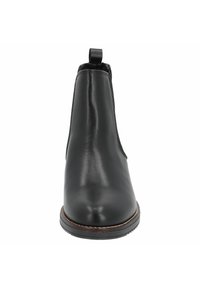 Botín de cuero negro hasta el tobillo con un acabado suave, puntera redonda y una tira en la parte trasera. Presenta una suela de goma resistente con un ligero relieve.