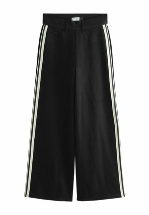 Pantalon large noir avec doubles bandes blanches courant de chaque côté, poches avant, passants pour ceinture et taille avec fermeture par bouton.