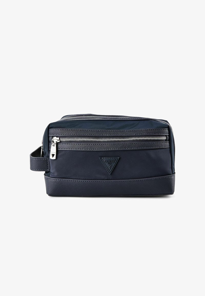 Trousse de toilette rectangulaire bleu marine avec poche zippée à l'avant, poignée de transport sur le côté et logo triangulaire en relief sur le panneau avant.