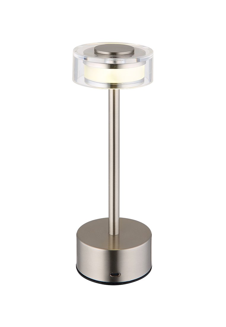 Lampa stołowa z wykończeniem z matowego metalu, przezroczystym, okrągłym kloszem i cylindrycznym korpusem, w którym znajduje się ciepłe białe światło. Zawiera port USB do ładowania.