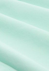 Mints zaļš audums ar gludu, nedaudz texturētu virsmu un smalku ribošanu, salocīts, lai parādītu dažādus slāņus un dziļumu.