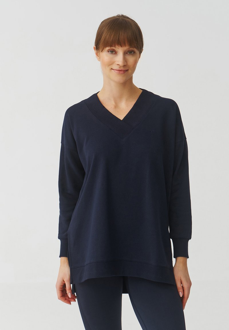 Marineblauwe V-hals sweatshirt van zachte stof, met lange mouwen en een relaxte pasvorm met een iets langere achterkant.