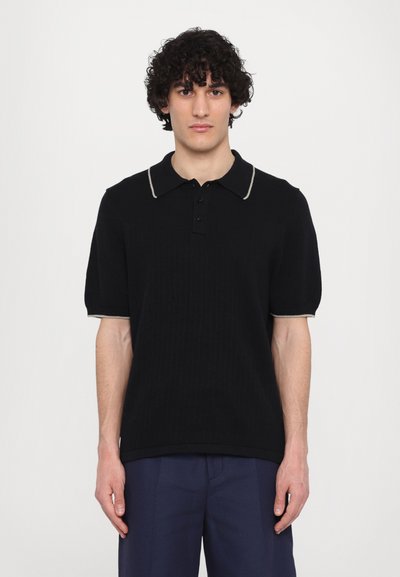 Polo shirt en tricot noir à manches courtes, présentant une texture côtelée et un col et des poignets contrastants en gris clair.