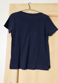 Mörkblå kortärmad t-shirt med rund halsringning, gjord av bomull, med sidofickor vid fållen och en slät yta.