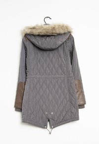 Szara pikowana kurtka z kapturem wyłożonym sztucznym futrem, skórzanymi detalami na rękawach oraz troczkiem u dołu. Posiada pionowe przeszycia i sięga do połowy długości ciała.