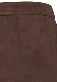 Gros plan sur un tissu en daim marron doux montrant une texture lisse et une couture horizontale près du bord supérieur.