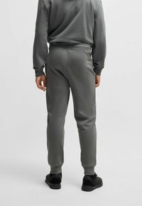Grijze joggingbroek met elastische tailleband en boorden, gemaakt van een katoenmix, met zijzakken en een gladde stof. Strakke pasvorm bij de enkels.
