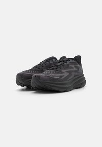 Scarpe da ginnastica nere con tomaia in maglia texturizzata, chiusura con lacci e suola in gomma. Progettate con una soletta imbottita e leggere.