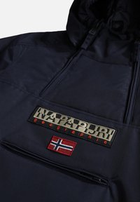 Veste à capuche bleu marine foncé avec poche zippée à l'avant, ornée d'un patch logo Napapijri Geographic et d'un patch drapeau norvégien.