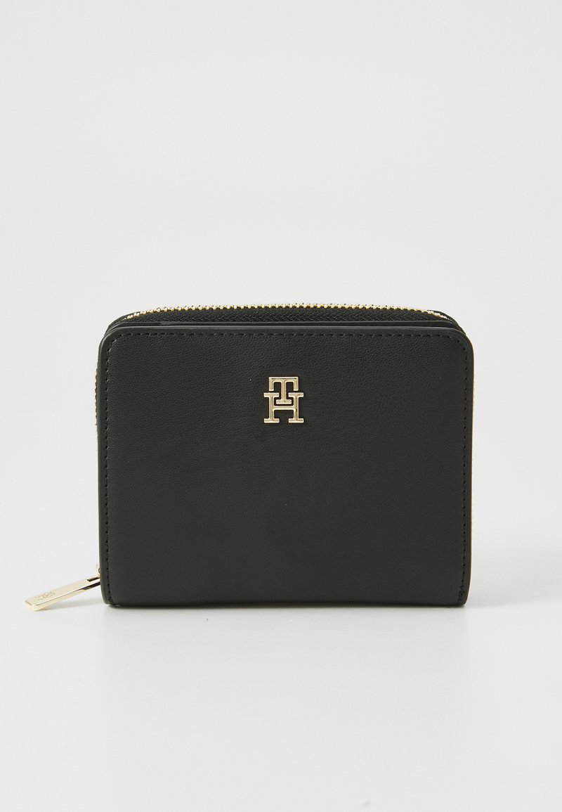 Black leather wallet with a smooth texture, rectangular shape, gold zipper, and a prominent gold logo on the front.
