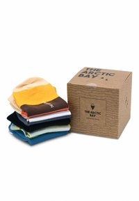 Ein Set aus sechs Socken in verschiedenen Farben, darunter Gelb, Braun, Marineblau und Grün, neben einer braunen Pappschachtel mit einem Logo präsentiert.