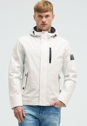 White waterproof jacket with a hood, black zipper accents, and buttoned side pockets. Features a logo patch on the sleeve.