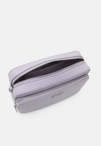 Bustina in pelle lavanda con due chiusure lampo in argento, design rettangolare elegante, logo impresso e texture liscia. Comparto interno visibile.