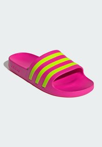Adidas flip-flop with a pink rubber base and a wide strap featuring three bold yellow-green stripes across the upper.
