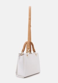 Vit vävd fusk läder tote bag med flätade bruna handtag och gyllene detaljer. Har en strukturerad form och en avtagbar axelrem.