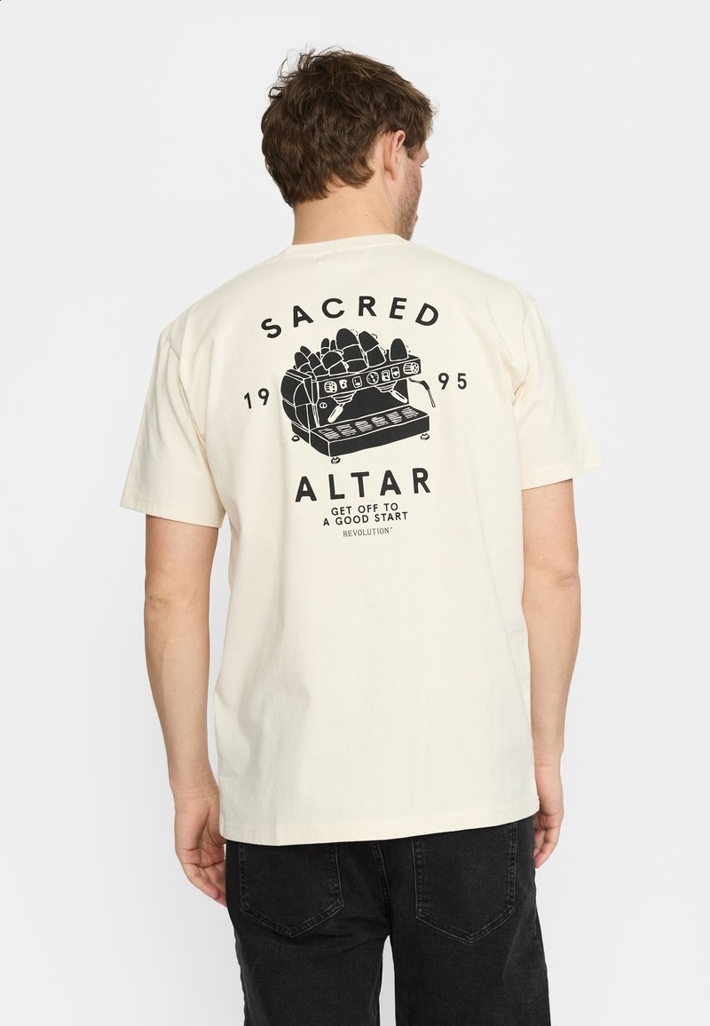 Crème-kleurig katoen t-shirt met een zwarte grafische print op de achterkant, die een koffiezetapparaat afbeeldt, met de tekst "SACRED ALTAR" erboven.
