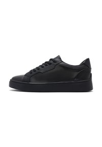 Baskets en cuir noir avec un bout arrondi, un laçage à l'avant et une semelle épaisse. Texture lisse avec de subtils accents de design sur le côté.