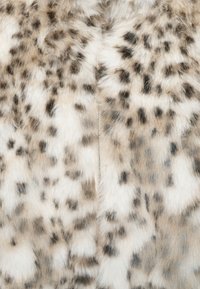 Zachte, gevlekte stof met vachten in tinten van wit, beige en bruin, met een centraal zichtbare rits.