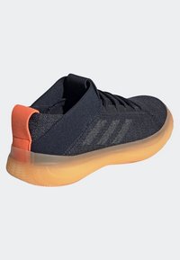 Scarpe da ginnastica blu navy con tomaia in rete, dettaglio arancione sul tallone e suola in gomma traslucida. Presentano tre strisce sui lati.