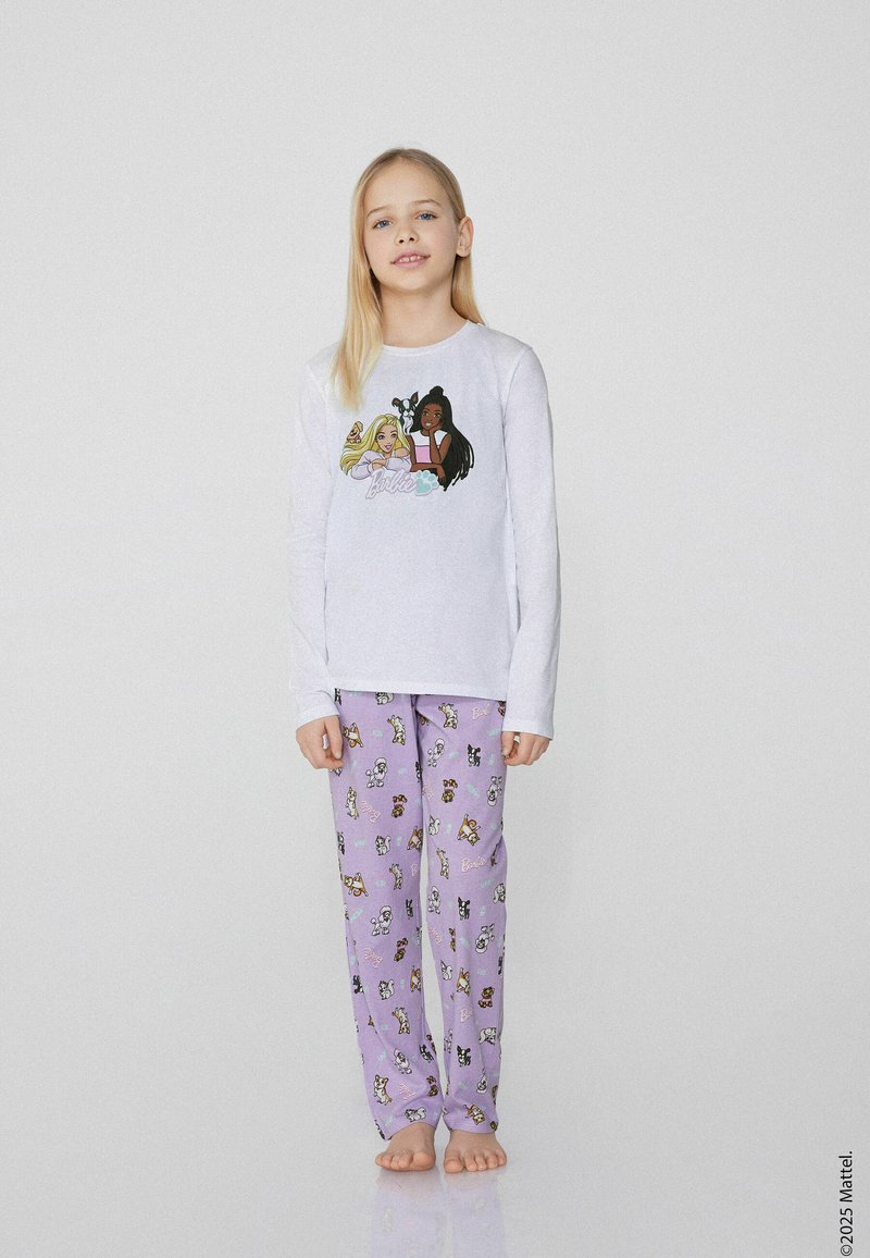 Bílý dlouhý rukáv top s barevnou grafikou postavy. Fialové pyžamové kalhoty s různými vzory kreslených psů. Měkký bavlněný materiál.