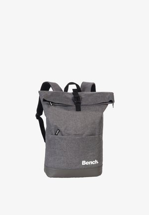 Gray roll-top backpack with black buckle, padded shoulder straps, front pocket, and white "Bench." logo near the bottom.