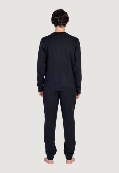 Set di felpa e pantaloni in cotone nero, vestibilità rilassata, collo rotondo, polsini a coste, superficie liscia, visualizzazione dal retro.