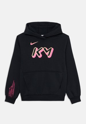 Melns kapucis ar priekšējo kabatu, kura dizainā ir pink un zelta "KM" logo un rozā liesmu akcenti uz kreisā piedurknes. Audums ir kokvilnas un sintētikas maisījums.