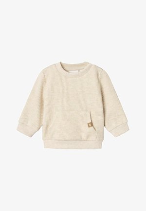 Krēmveida ribota džemperis ar garām piedurknēm, apaļu kakla izgriezumu un priekšējo kabatu. Uz kabatas ir neliela brūna etiķete. Mīksta tekstūra.