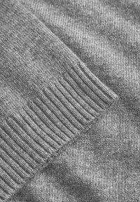 Gray knitted fabric with a smooth texture and ribbed cuffs. Soft, medium-weight material with subtle variations in shading.