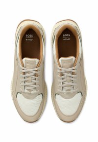 Sneaker beige chiaro con tomaia in rete traspirante, dettagli verdi e soletta Ortholite®. Punta arrotondata e suola in gomma testurizzata.