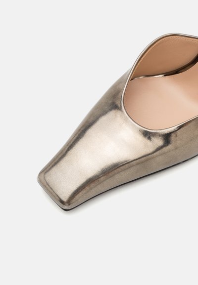 Zapato de tacón alto plateado metálico con punta afilada y laterales recortados. Textura suave y diseño minimalista. Adecuado para ocasiones formales.