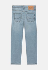 Heledad sinine teksad sirge sääre disainiga, kus on kaks tagumist taskut, kontrastne õmblus ja pruun silt vöökoht.